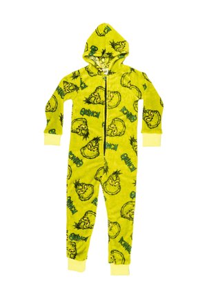 Ragazzo in piedi a piedi nudi che indossa una tutina in pile verde a tema Grinch con cappuccio e polsini gialli su maniche e caviglie.