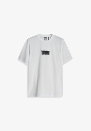 Witte katoenen T-shirt met ronde hals, korte mouwen, met een zwart rechthoekig logo-patch met de tekst "I AM".