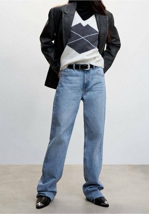 Jeans de pierna recta azul claro, combinados con un blazer negro y un suéter de patrón que presenta formas de diamante en gris y crema. Botas negras de punta.