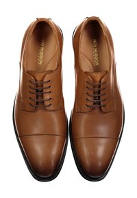 Braune Leder-Halbschuhe mit glatter Oberfläche, runder Zehenpartie und schwarzer Sohle. Mit Schnürsenkeln und perforierten Details nahe der Zunge.