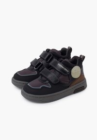 Scarpe sportive nere con cinturini in Velcro, dotate di un collo imbottito, accenti grigi e una suola texturizzata. Progettate per comfort e stabilità.
