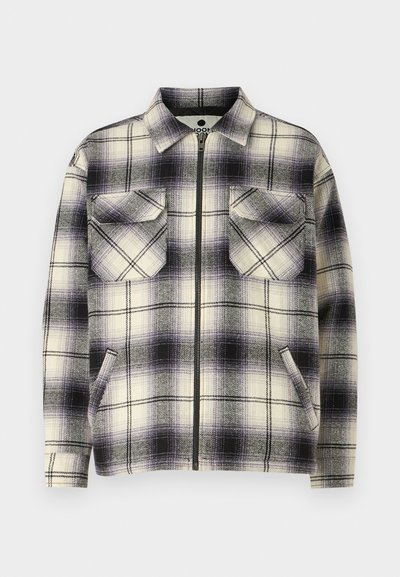 Plaid jacket in cream and purple hues, featuring a zip closure, two chest pockets, and a collar. Soft, textured fabric with a boxy shape.