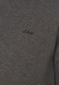 Pull en tricot gris présentant un tissu texturé, un col rond et un logo brodé en noir sur le devant.