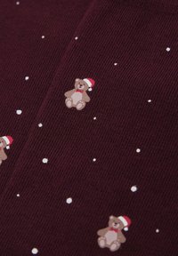 Tissu en maille bordeaux parsemé de petits pois blancs et de petits ours marron clair portant des bonnets rouges, ajoutant des détails ludiques à la texture.