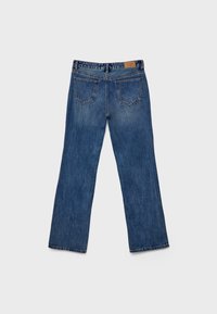 Denim hlače v srednji modri prani barvi, naravnost krojene, z rahlim bledežem. Imajo dve zadnji žep in svetlo rjavo oznako blagovne znamke na pasu.