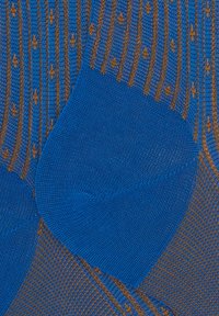 Calzini blu lavorati a maglia con un design testurizzato, strisce marroni e piccoli motivi, creando un contrasto visivo distintivo.