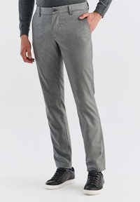 Szare, teksturowane spodnie o slim fit, z gładkim przodem i bocznymi kieszeniami, sparowane z czarnymi sneakersami na casualowy wygląd.