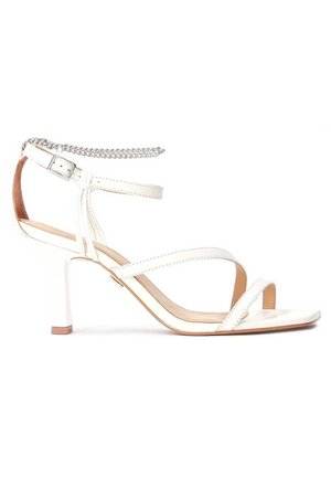 Białe sandały na wysokim obcasie z wieloma krzyżującymi się paskami, detalem łańcucha na kostce i gładkim wykończeniem. Otwarty nosek, cienki obcas w kształcie szpilki.