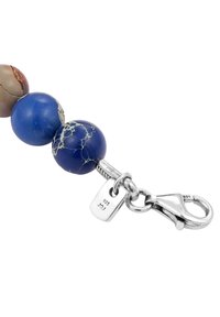 Perlenarmband mit blauen und braunen polierten Steinen, silberner Verschluss mit "925" Punze und einer glatten, glänzenden Oberfläche.