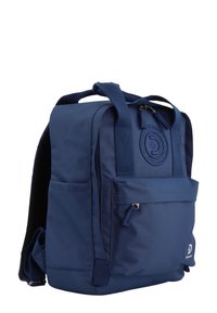 Zaino blu realizzato in tessuto resistente; dotato di spallacci, tasche laterali e una patch con logo. Disponibile con comparto principale con cerniera e tasca frontale.