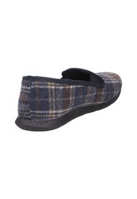 Pantofole di flanella con un motivo a quadri blu navy, marrone e giallo, dotate di una suola piatta in gomma nera e un bordo superiore elastico e imbottito.