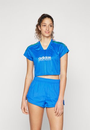 Blue cropped sports top with vertical stripes, featuring "adidas SPORTSWEAR" logo. Paired with matching blue shorts, both made of lightweight material.