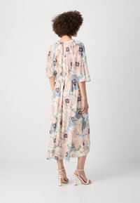Floral midi dress in pastel colors with a cinched waist, flutter sleeves, and a flowing bottom hem. Features a patterned fabric and keyhole back.
