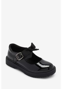 Chaussure Mary Jane en cuir verni noir avec un bout rond, ornée d'un nœud en velours et d'une boucle argentée sur une semelle noire surélevée.