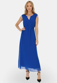 Niebieska sukienka maxi z dekoltem w kształcie litery V, taliowana i z lejącym się materiałem. Posiada ozdobny akcent przy dekolcie oraz gładką fakturę.