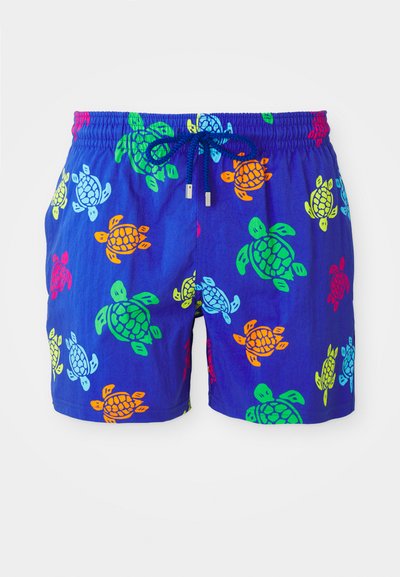 Pantaloni da bagno blu con motivo di tartarughe in arancione, verde, rosso e giallo. Vita elastica con cordino e punte metalliche.