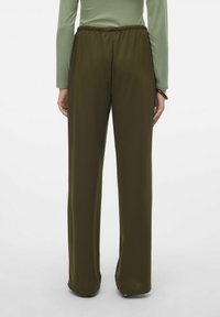 Pantalons larges, extensibles et de couleur vert foncé avec une taille élastique, en tissu lisse, de longueur ajustée tombant près du sol.