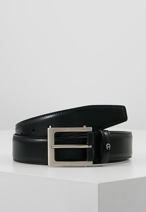 Zwarte leren riem met een gladde textuur, rechthoekige zilveren gesp en gaatjes voor aanpassing. Beschikt over een strakke, minimalistische uitstraling.