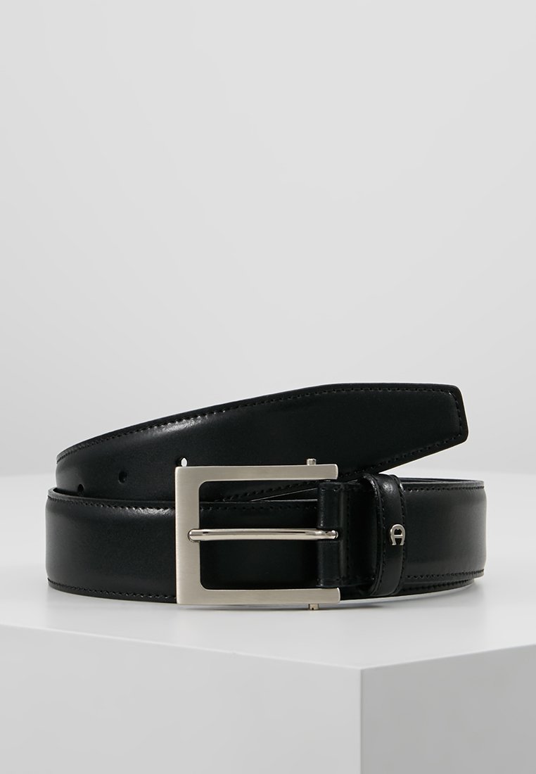 Cinturón de cuero negro con una textura suave, hebilla rectangular de plata y agujeros perforados para ajuste. Presenta un diseño elegante y minimalista.