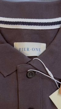 Brūns polo krekls ar pogājamu apkakli, ar baltu un tumši zilu svītru, teksturēta auduma, un etiķeti ar uzrakstu "PIER ONE."