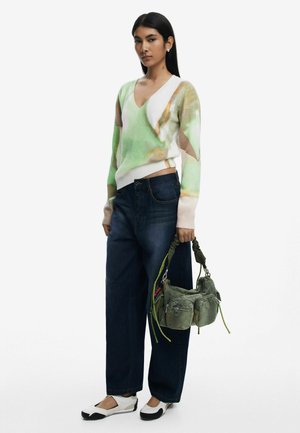 V-neck sweater in green and beige hues, paired with dark blue wide-leg jeans. Accessorized with a green bag featuring adjustable straps.