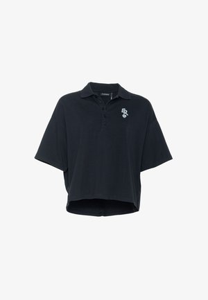 Svart oversized kortermet polo med tre knapper og liten hvit brodert logo på venstre bryst.