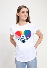 Bílý tričko s krátkým rukávem s vícerobarevným srdcovým grafickým motivem a textem "HAKUNA MATATA" v námořnické modři. Materiál vypadá hladce a lehce.