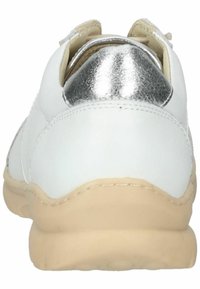 Sneaker bianco con un accento metallico argento sul tallone, tomaia in pelle liscia e suola in gomma beige, caratterizzato da dettagli cuciti lungo i bordi.