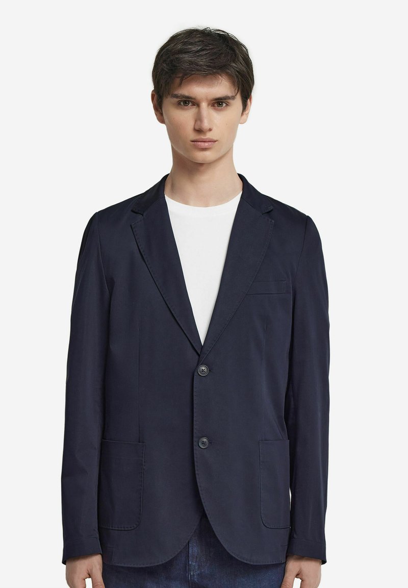 Mörkblå kavaj i lätt tyg, med två framfickor, en enda knappstängning och en kavaj med slag.