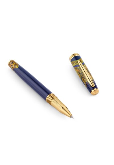 Stylo roller bleu et or avec un capuchon retiré, présentant des motifs décoratifs complexes en or et colorés sur une surface blanche.