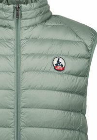 Gilet imbottito senza maniche verde chiaro con colletto alto, texture trapuntata e una toppa rotonda con logo vicino alla zip.