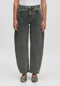 Hoogwaardige, wijde jeans in vervaagd grijs denim met vijf zakken en zichtbare stiksels, gecombineerd met zebrastrepen instapschoenen.