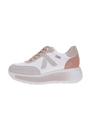 Zapatilla deportiva de mujer blanca y beige con suela gruesa, detalles en ante, cordones delanteros y pequeña etiqueta de la marca en el lateral, vista desde el lado exterior.