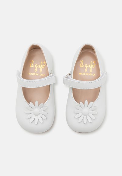 Zapatos Mary Jane de cuero blanco con un aplique de margarita en la punta, una correa sobre el empeine y un interior beige, marcados "il gufo" fabricados en Italia.