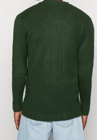 Groene gebreide trui met lange mouwen, ronde hals, geribbelde manchetten en zoom, met een zachte textuur en een comfortabele pasvorm.