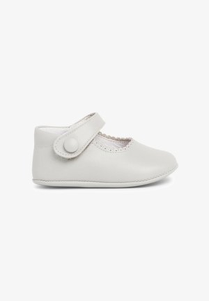 Chaussure pour bébé en cuir gris clair avec un bout rond, des détails en feston le long de l'ouverture et une sangle sécurisée avec un bouton rond de fermeture.