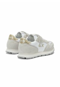 Sneaker bianche e grigio chiaro in materiali scamosciati e sintetici. Presentano un accento dorato sul tallone e dettagli con il logo.