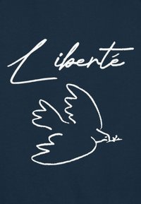 Un tissu bleu marine comportant une silhouette blanche d'une colombe portant une branche d'olivier, accompagnée du texte « Liberté » en style cursif au-dessus.