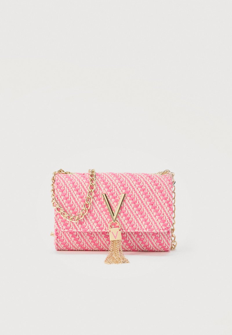 Ροζ υφαντό τσαντάκι χειρός με χρυσή αλυσίδα, χρυσή αγκράφα σε σχήμα V και λεπτομέρεια με φουντίτσα σε απλό φόντο.