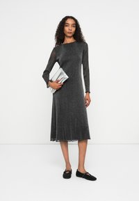 Fémes szürke ruha hosszú, áttetsző ujjal, bővülő szoknyával és csipke díszítéssel. Ezüst clutch táskával és fekete gyöngyös slip-on cipőkkel párosítva.