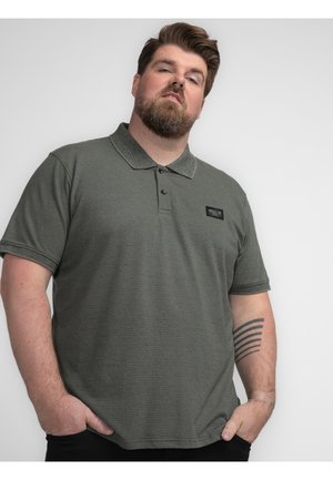 Groene gestreepte poloshirt met een gestructureerde stof, knoopsluiting en een klein logo-opdruk op de borst. Korte mouwen en een klassiek kraagontwerp.