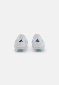 White soccer cleats with blue accents, textured material, and transparent sole. Features three blue stripes on each heel.
