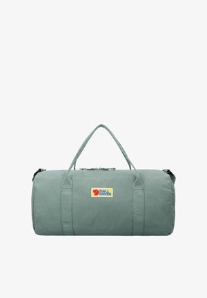 Borsa duffel verde di forma rotonda, realizzata in tessuto resistente. Presenta manici doppi e il logo Fjällräven in blu e giallo.