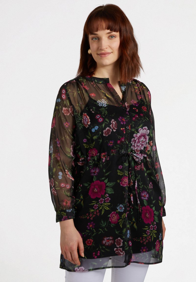Durchsichtige schwarze Bluse mit buntem Blumenmuster, langen Ärmeln, Knopfverschluss und Kordelzug in der Taille. Leichtes Material mit weicher Textur.