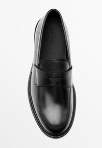 Schwarze Lederloafer mit einer glatten Textur, die ein gesticktes Design und ein dekoratives Band über dem Obermaterial aufweisen. Schlichte, abgerundete Form.