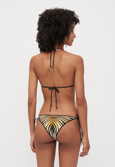 Bikini z vrhnjim delom na vezanje, v črni barvi, in spodnjim delom z večbarvnimi vzorci z zlatimi akcenti. Material izgleda gladek; oblikovanje vključuje navpične črte.