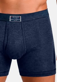Marinblå bomullsboxershorts med en texturerad ribbad design och ett elastiskt midjeband med varumärkesdetalj. Har en framficka för stöd.