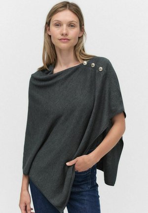 Grå stickad poncho med draperad halsringning, med tre dekorativa silverknappar på ena axeln och en lös, avslappnad passform.