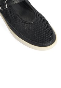 Schwarzer perforierter Lederschuh im Mary Jane-Design, mit verstellbarem Riemen, runder Spitze und hellfarbener Gummisohle.