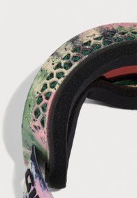 Spalvotas šalmas su taškiniais raštais, juoda putų paminkštinimu ir orui pralaidžiomis tinklinėmis dalimis. Kontūruota forma patogumui ir pritaikymui.